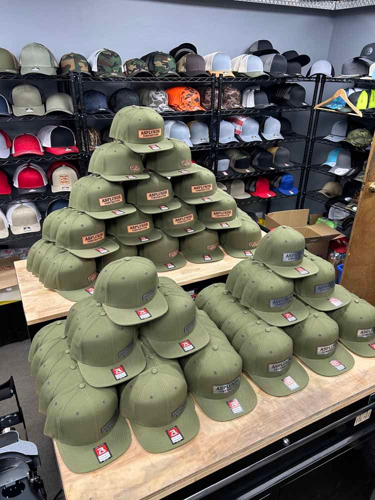 A bunch of hats are stacked on top of each other on a table in a store.
