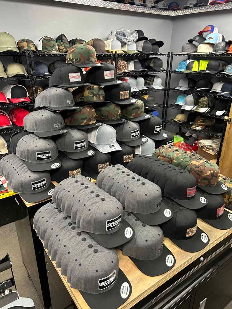 A bunch of hats are stacked on top of each other on a table in a store.