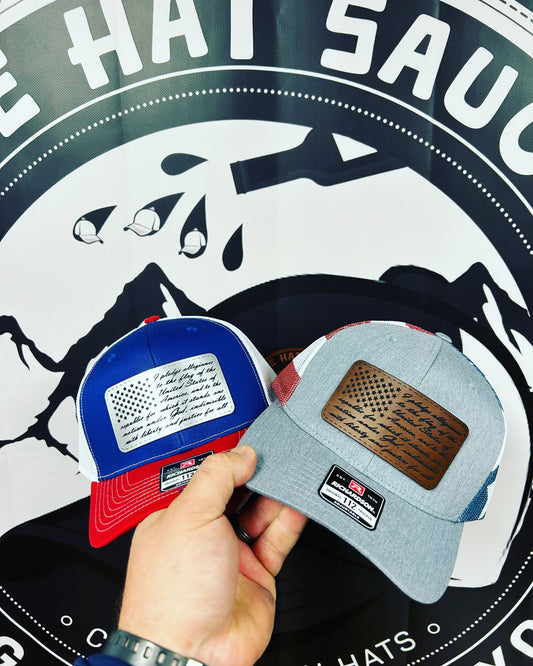 A person is holding two hats in front of a hat sauce logo