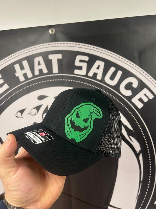 A person is holding a hat in front of a sign that says hat sauce