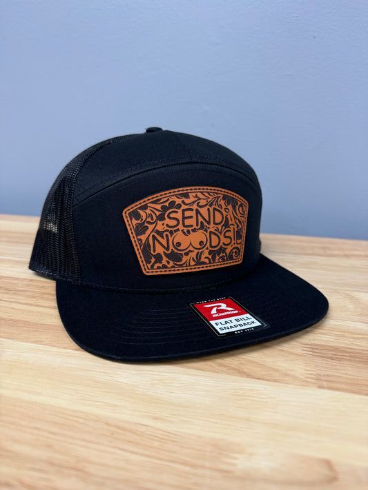 A black hat is sitting on top of a wooden table.