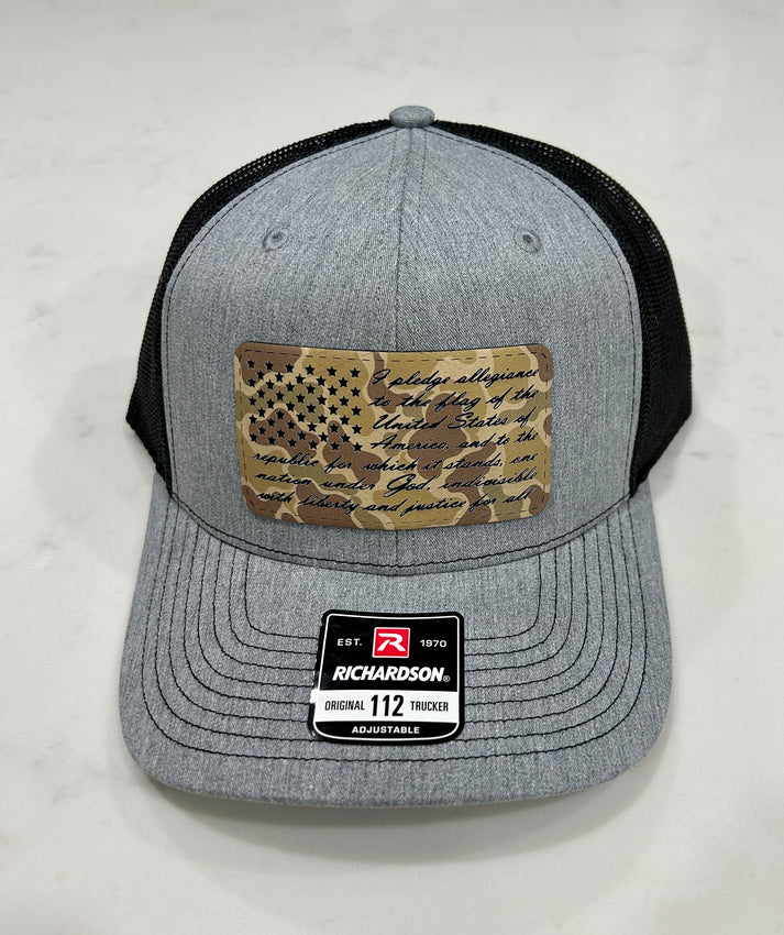 A grey and black baseball cap with an american flag on it.