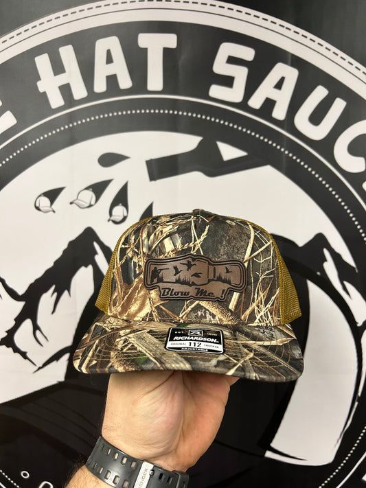 A person is holding a hat in front of a hat sauce logo