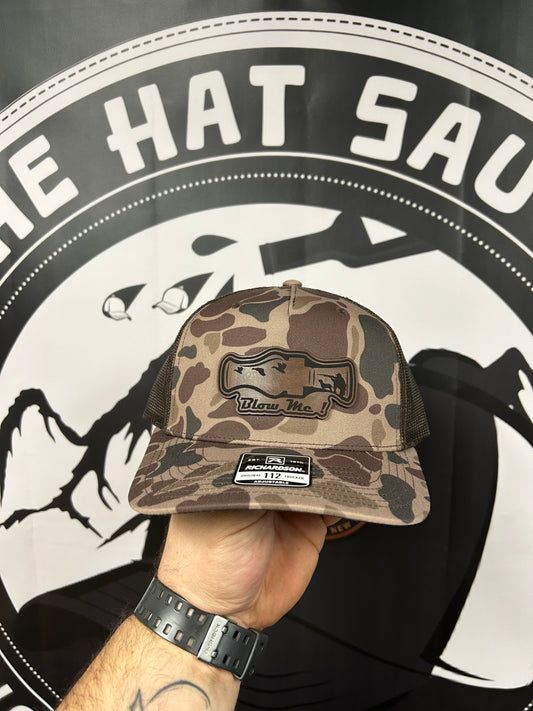 A person is holding a hat in front of a sign that says 