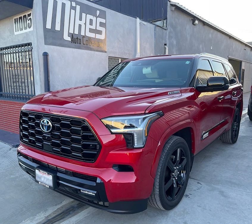 Red Toyota SUV parked outside a building with a “Mike’s” sign