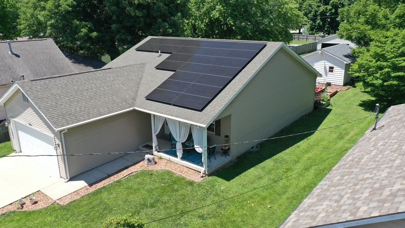 An aerial view of a house with solar panels on the roof.