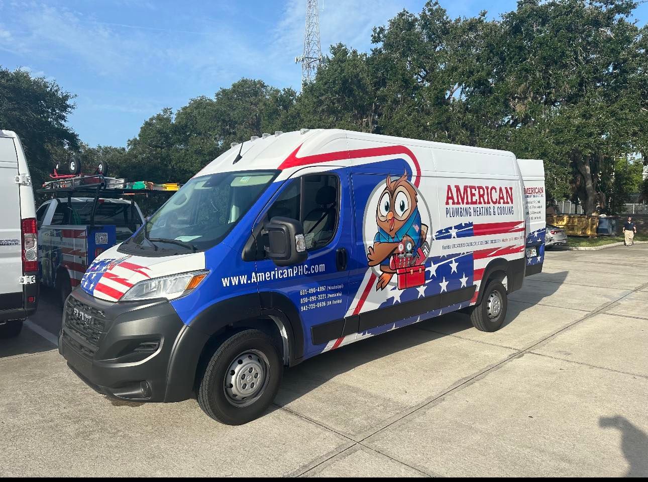 A blue and white american for a year van is parked in a parking lot.