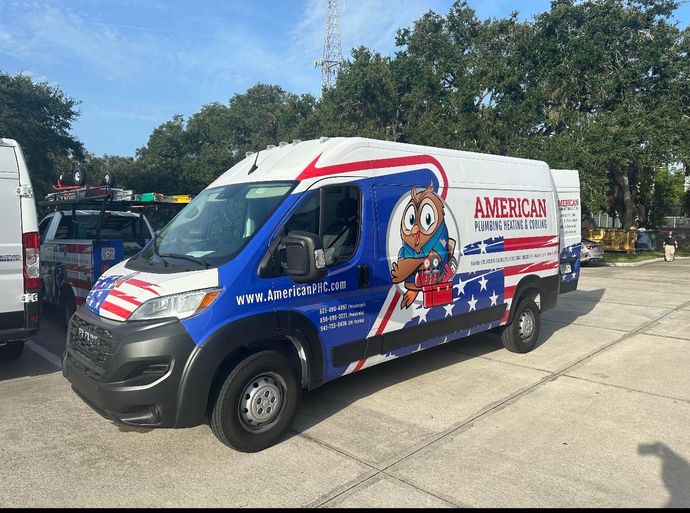 A blue and white american for a year van is parked in a parking lot.