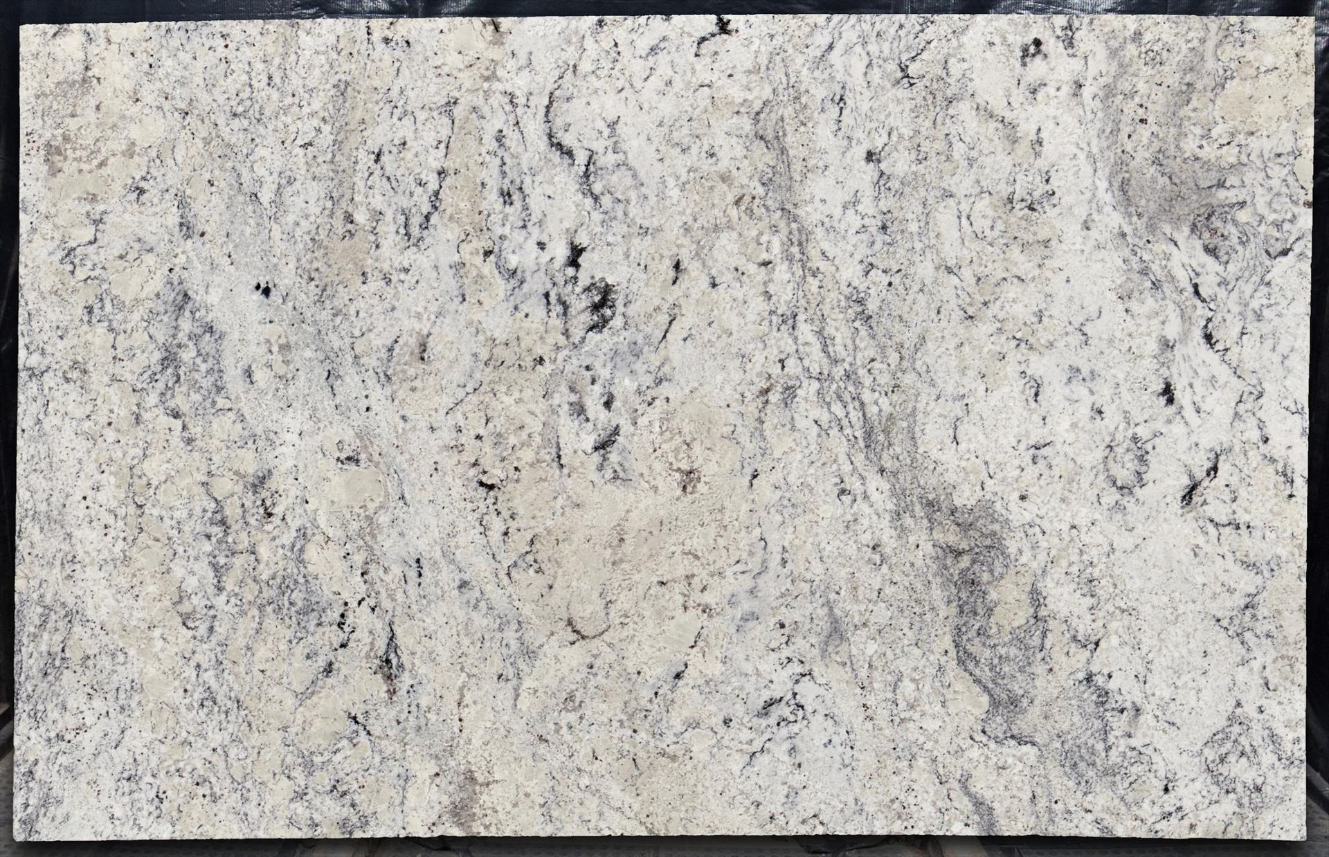 Cream-colored granite slab with black and gray speckles and veining.