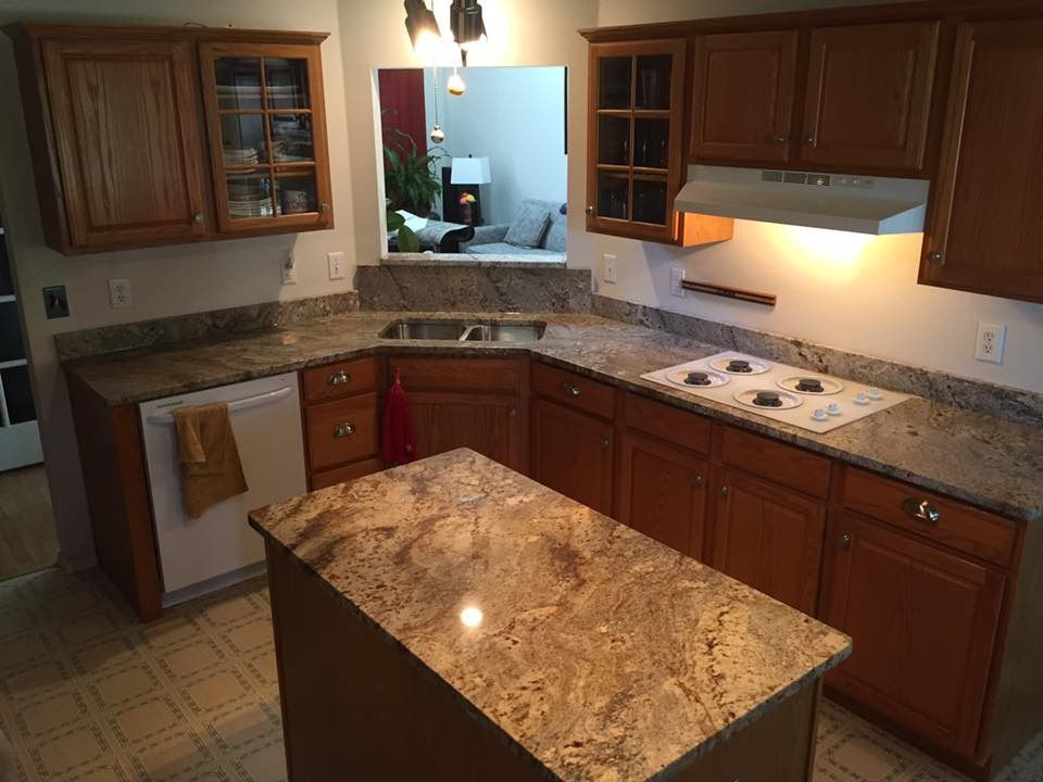Kitchen with brown cabinets, granite countertops, and an island.
