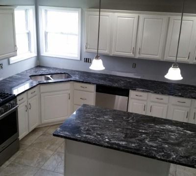 Kitchen with white cabinets, dark countertops, and a central island.