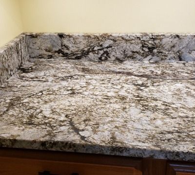 Granite countertop with black veining and light, neutral tones.