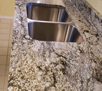 Granite kitchen countertop with a stainless steel double sink.