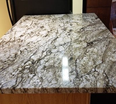 Close-up of a granite countertop with a white, gray, and brown swirling pattern.
