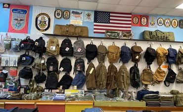 Wall of hats and jackets in a shop, with police patches and an American flag above the display