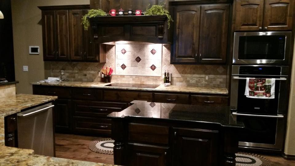 A kitchen with stainless steel appliances and wooden cabinets.