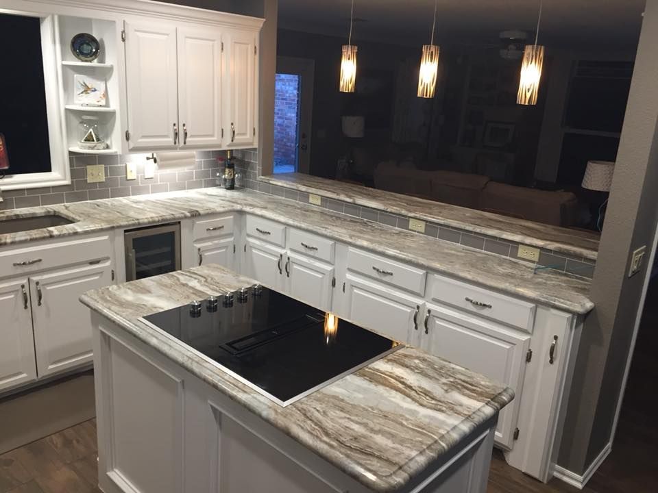 A kitchen with a large island and a stove top oven.