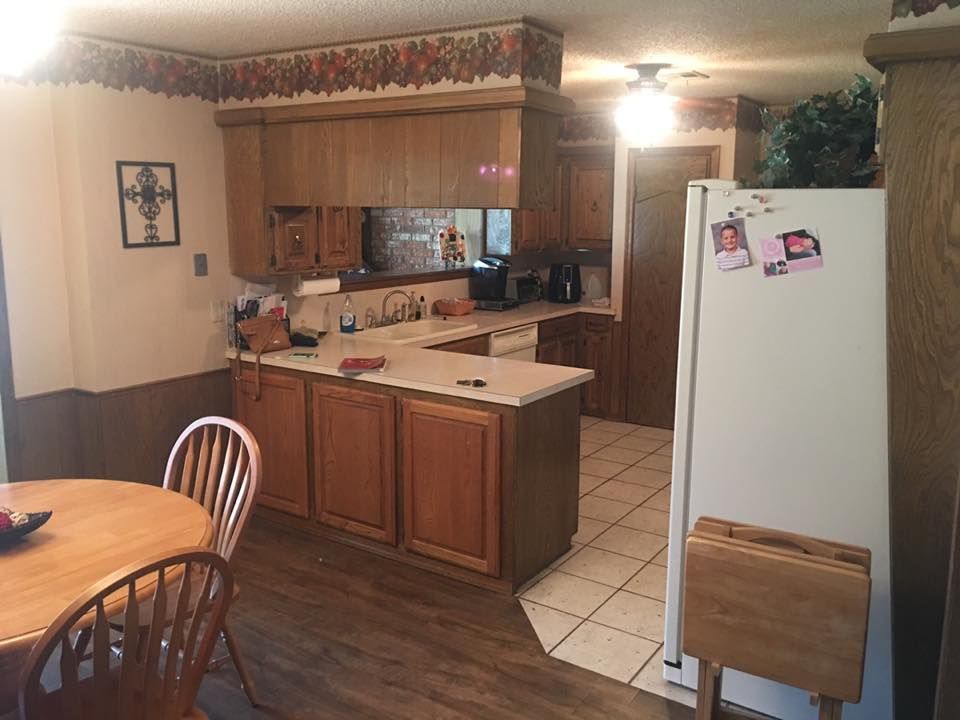 A kitchen with a table and chairs and a refrigerator.