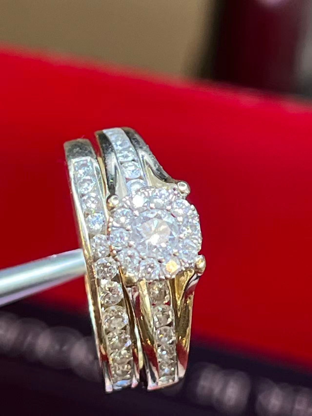 A yellow gold wedding ring set featuring a round diamond halo centerpiece and diamond-encrusted bands.