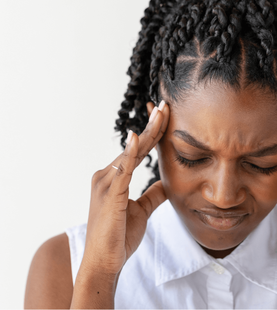 Woman holding her head in pain, appearing to experience a headache or migraine
