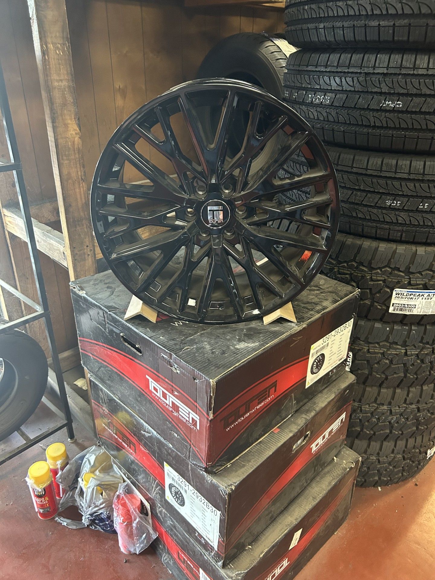 A black wheel is sitting on top of a stack of boxes.