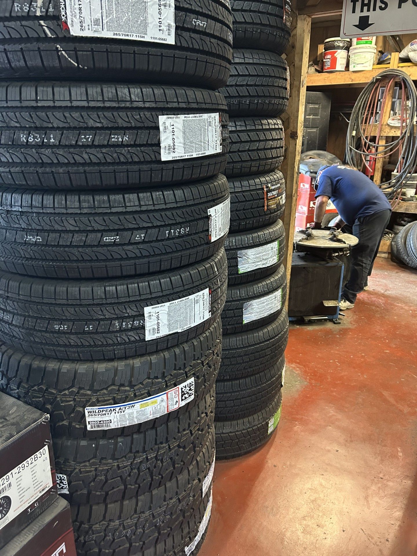 A man is working on a tire in a tire shop.