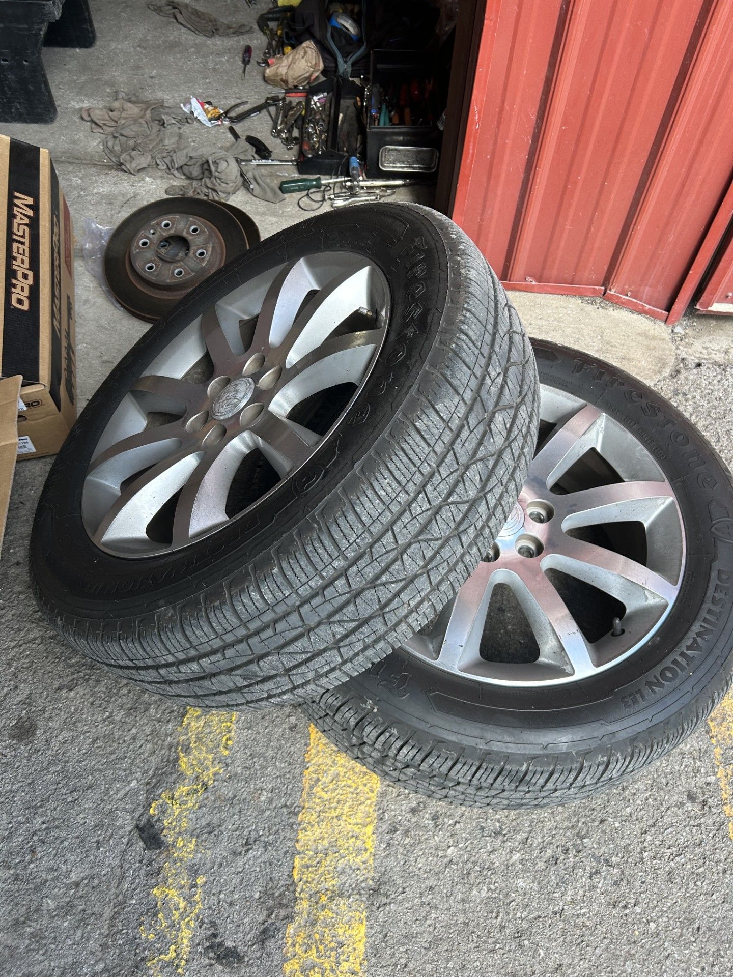 Two tires are stacked on top of each other in a parking lot.