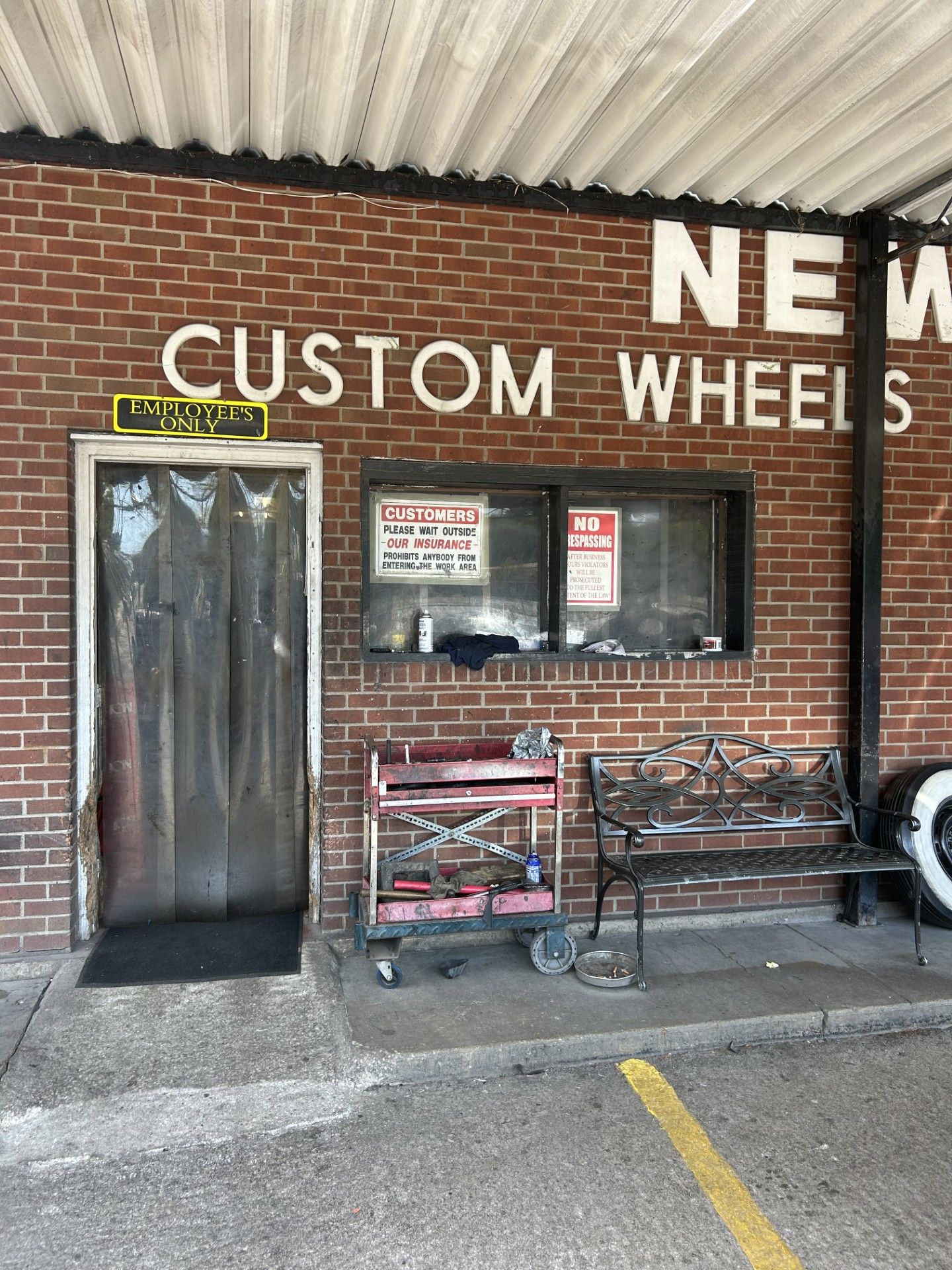 A brick building with the words `` new custom wheels '' painted on it.