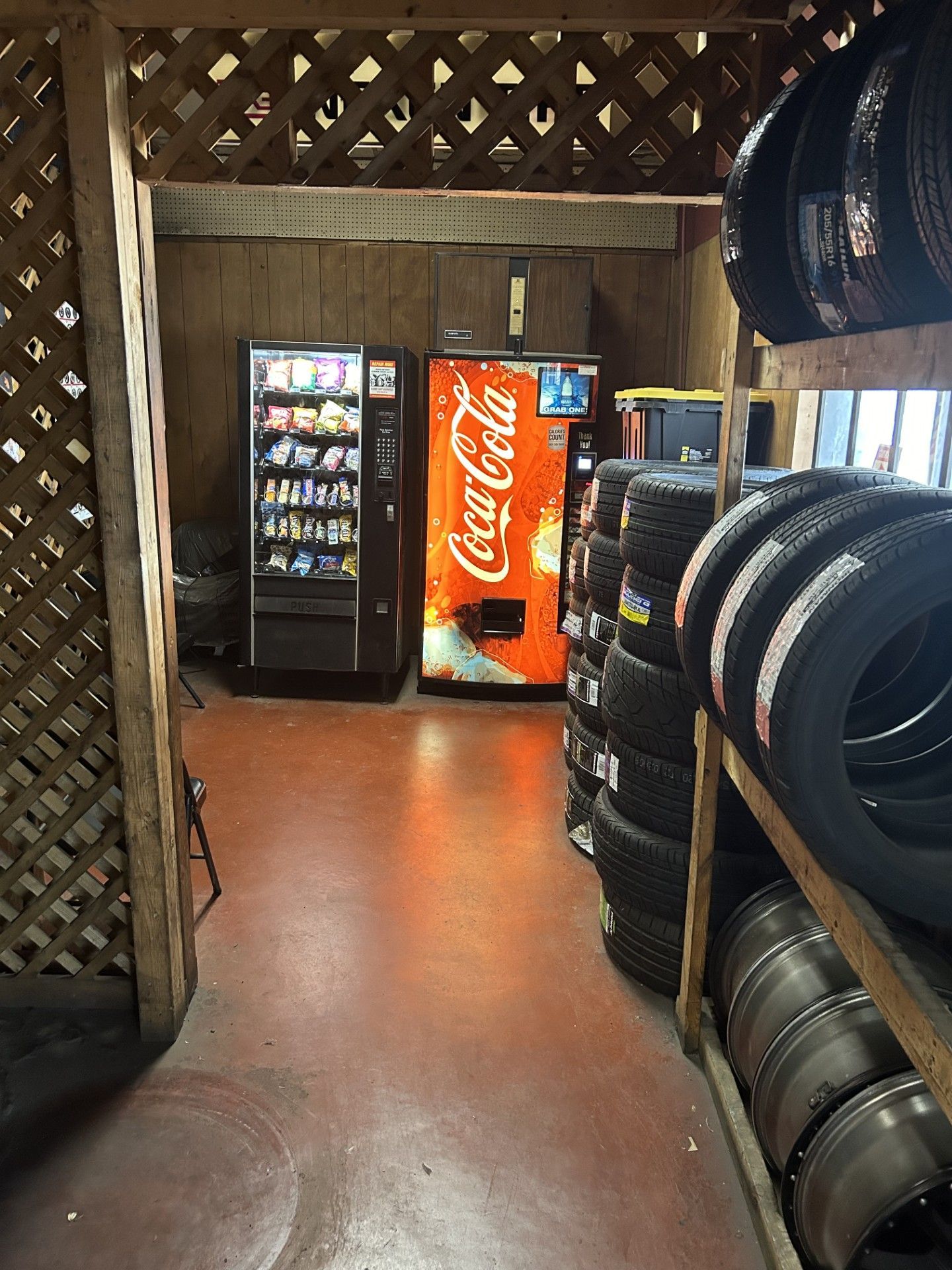 There is a coca cola vending machine in the middle of the room.