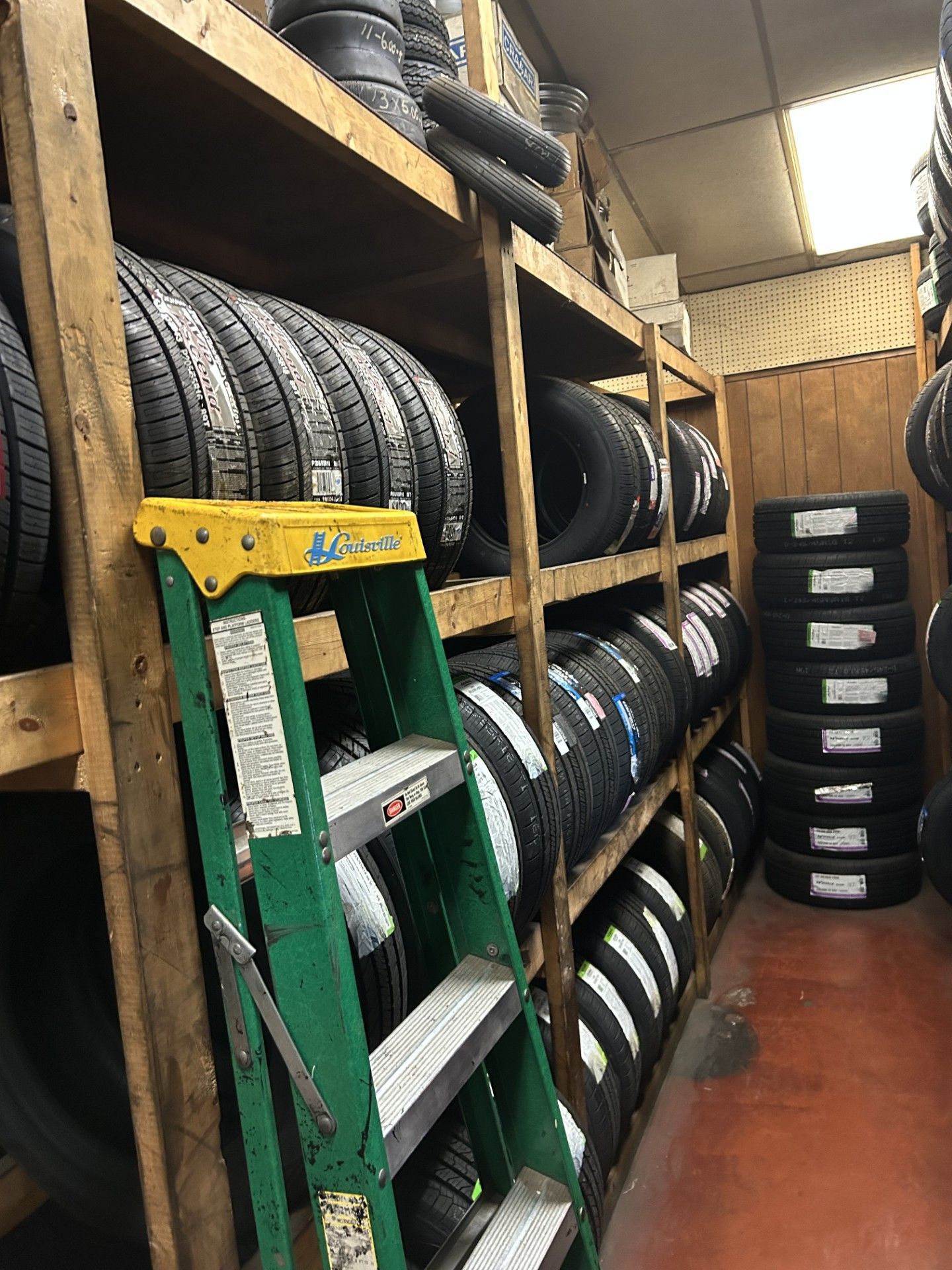 A room filled with lots of tires and a ladder.