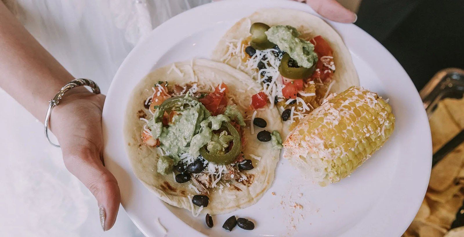 A plate of tacos and corn on the cob