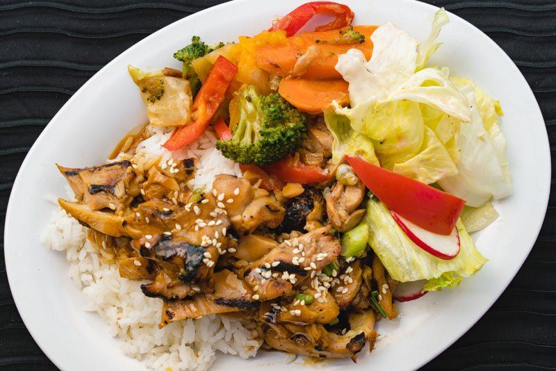 A plate of food with rice and vegetables on a table