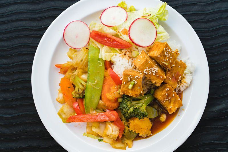 A white plate topped with rice , vegetables and meat