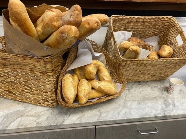 Three baskets of bread are sitting on a counter.