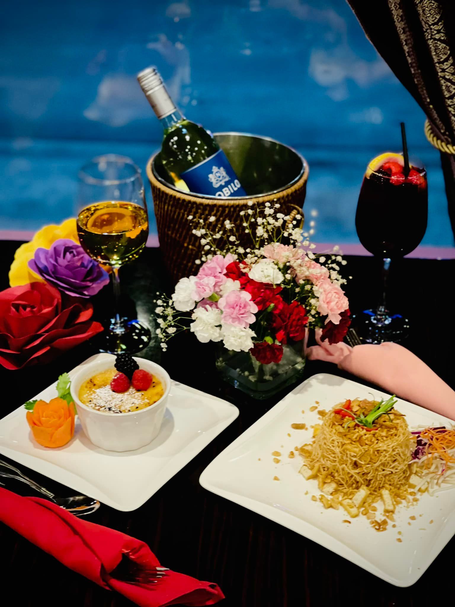 A table topped with plates of food and a bottle of wine.