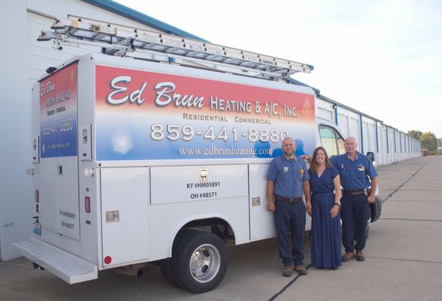 Ed Brous Heating and Cooling service truck with three workers standing beside it on a driveway
