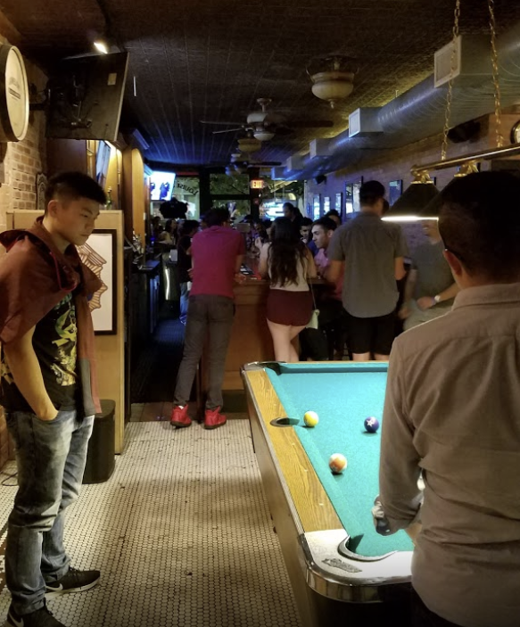 people playing pool inside the tavern