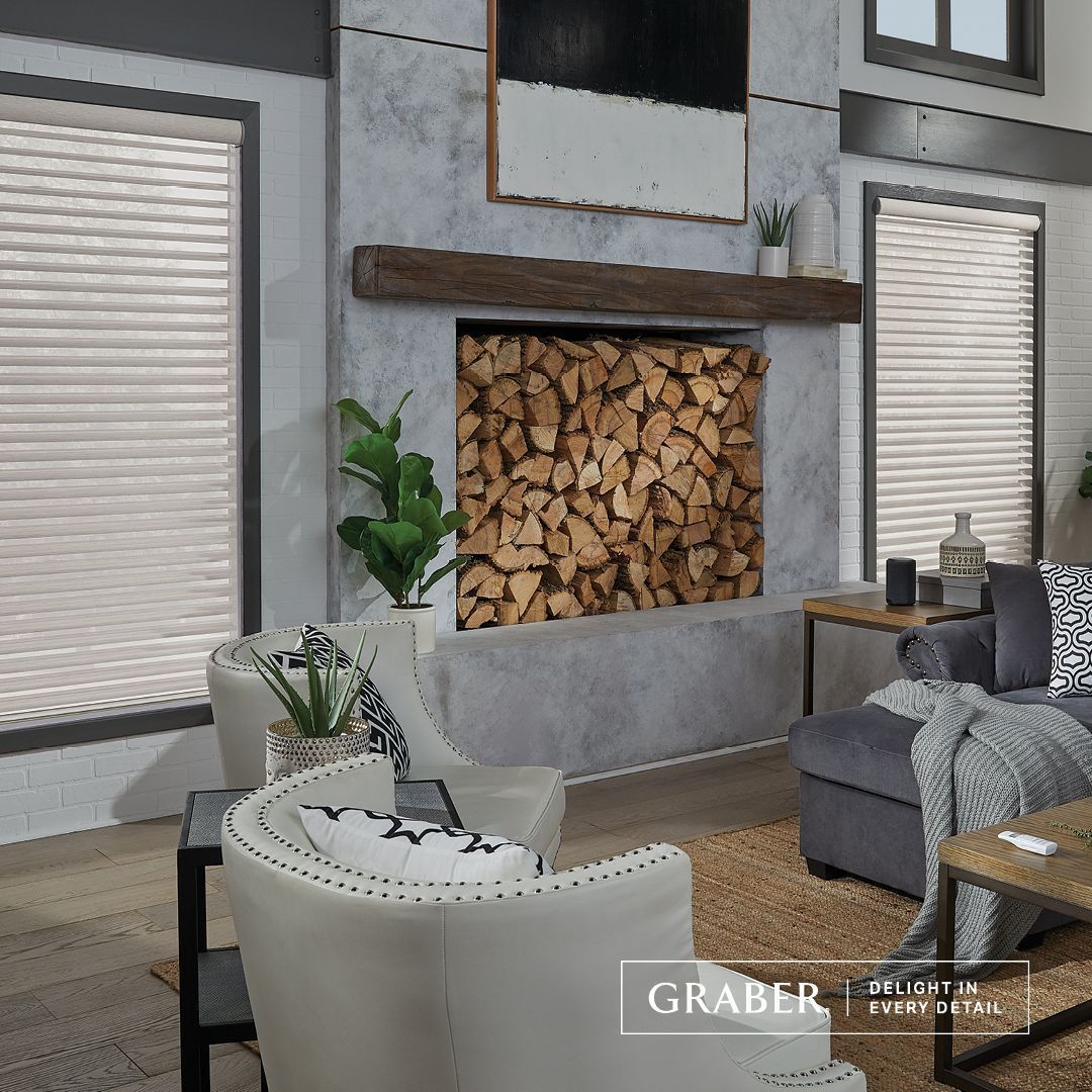 Living room with fireplace, white armchairs, and blinds; a neutral color scheme.