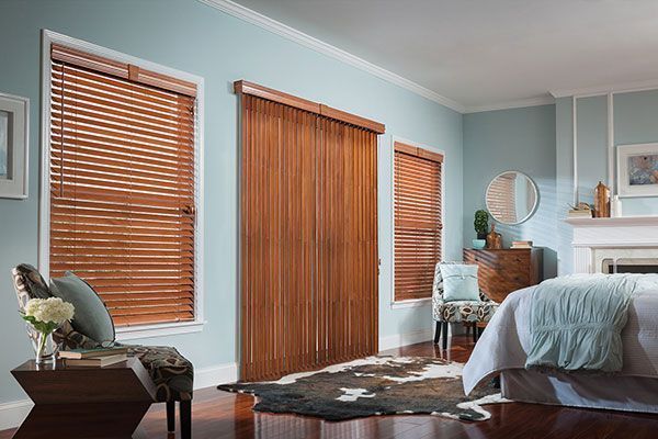 Bedroom with wooden blinds, light blue walls, and a cowhide rug.