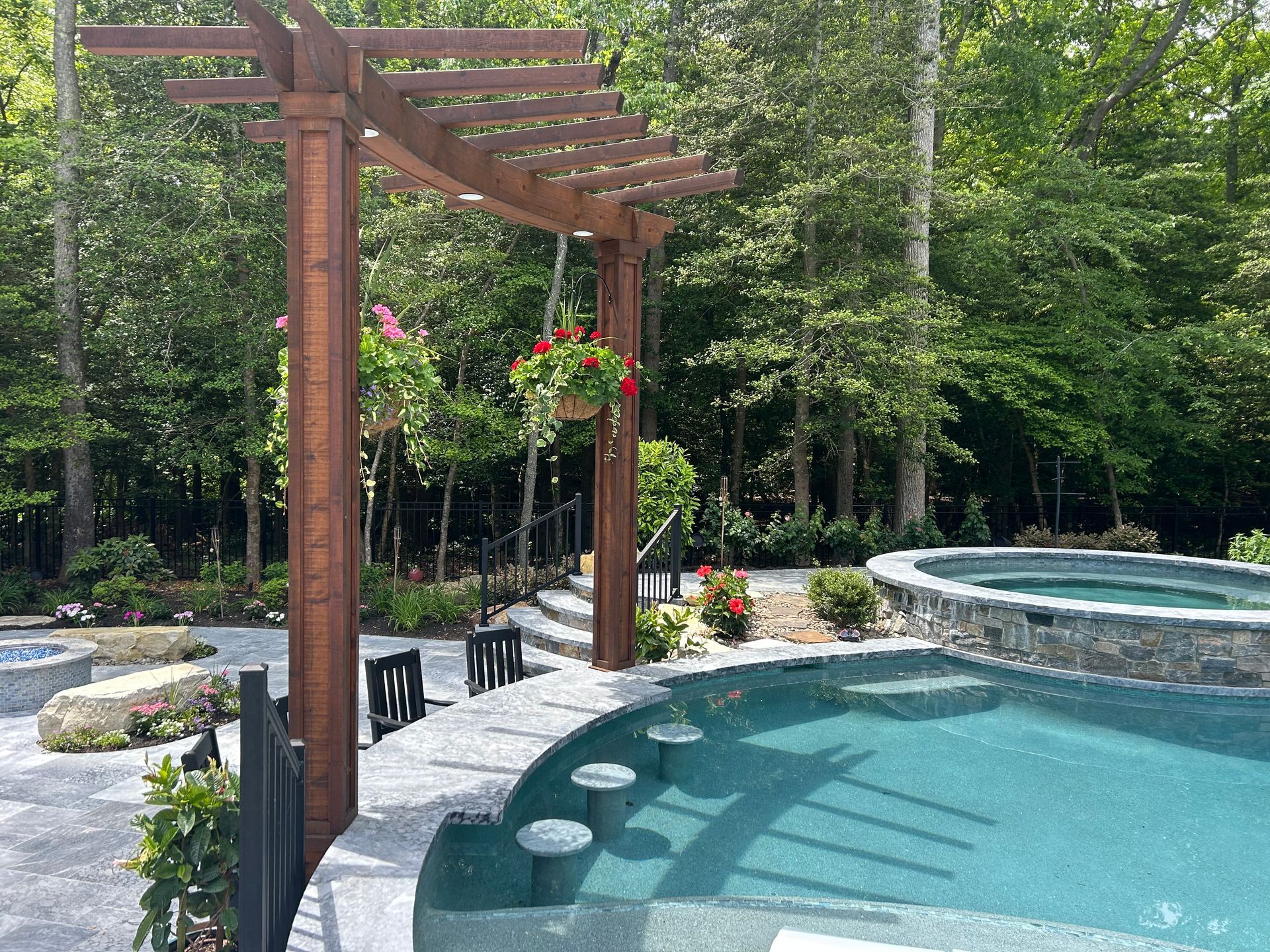 A large swimming pool with a wooden pergola over it