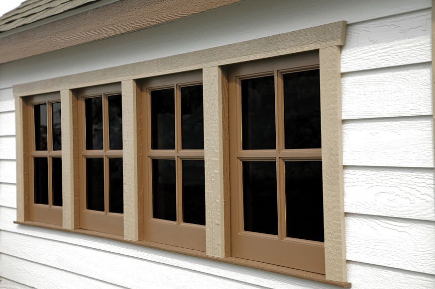 a white house with brown windows on the side