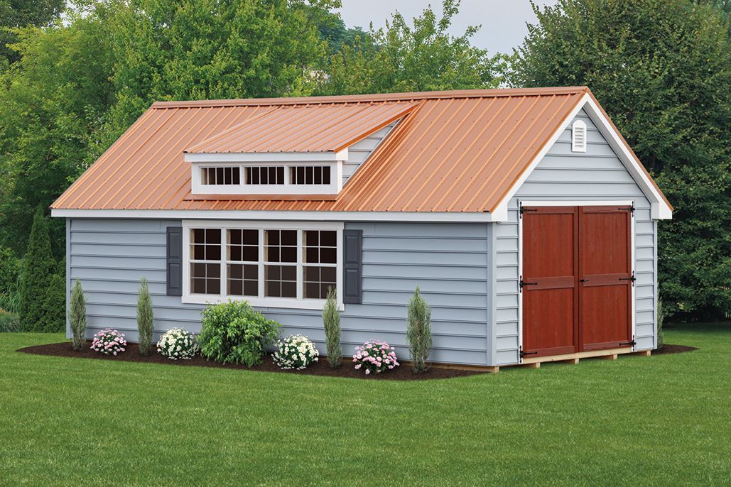 a blue shed garage with a red door and a brown roof