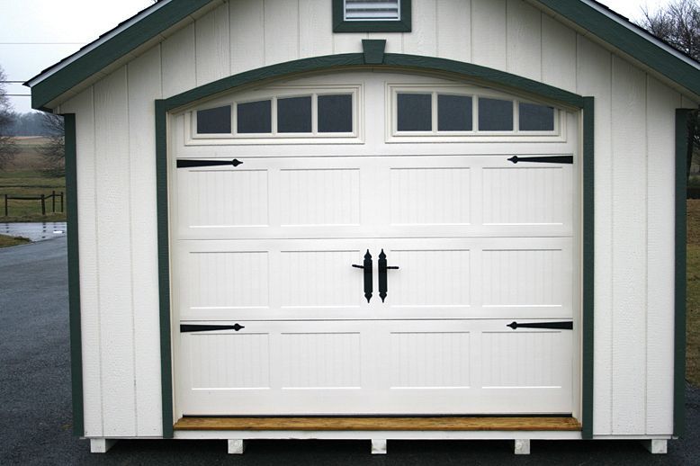 a white garage with a green trim and a white door