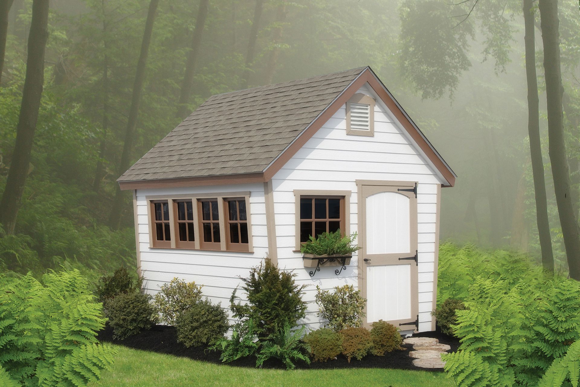 a small white house in the middle of a forest