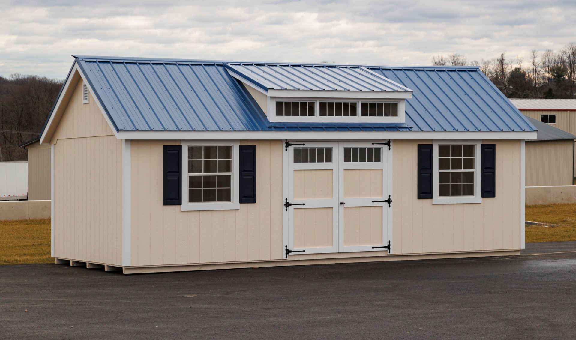 a small house with a blue roof and black shutters