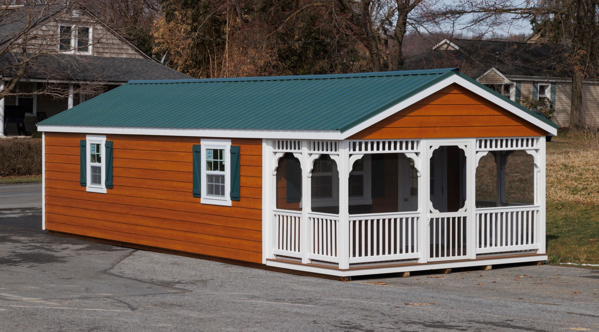 a small house with a screened in porch and a green roof
