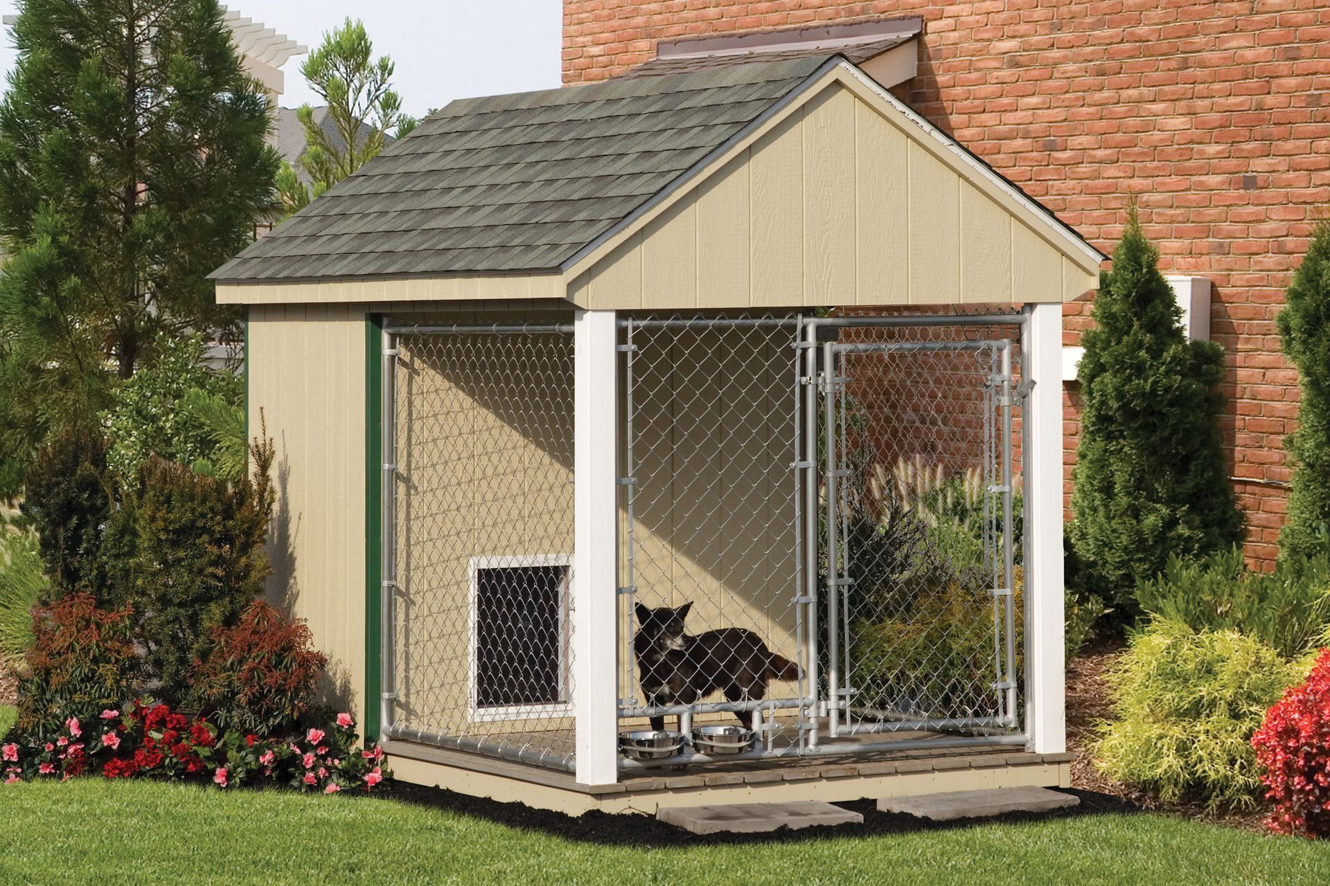 a dog kennel with a chain link fence in front of a brick house