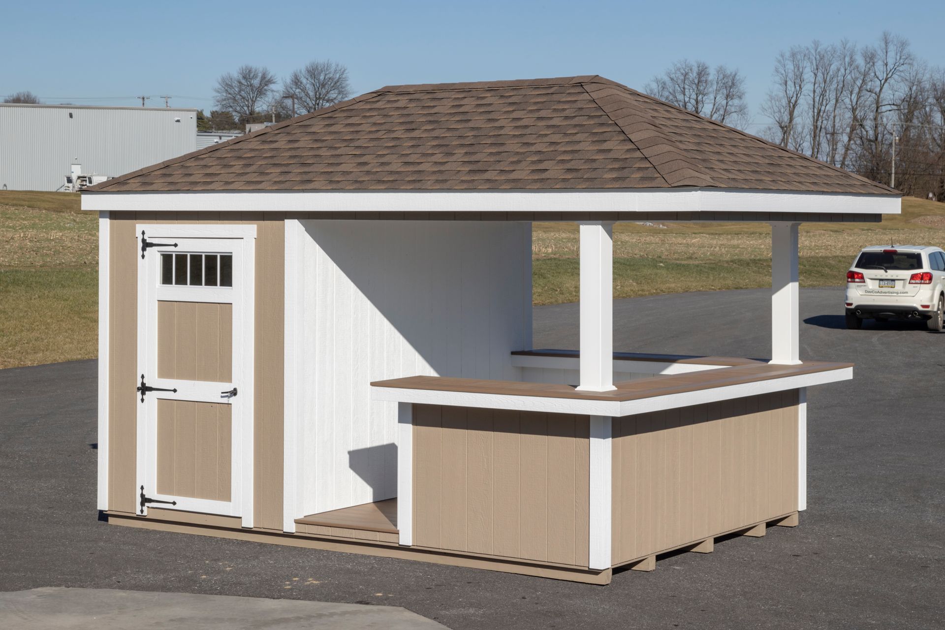 a shed with a brown roof and a white car parked in front of it