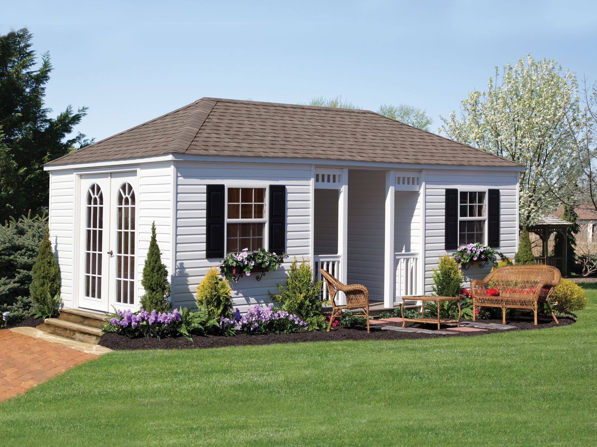 a small white house with black shutters and a porch