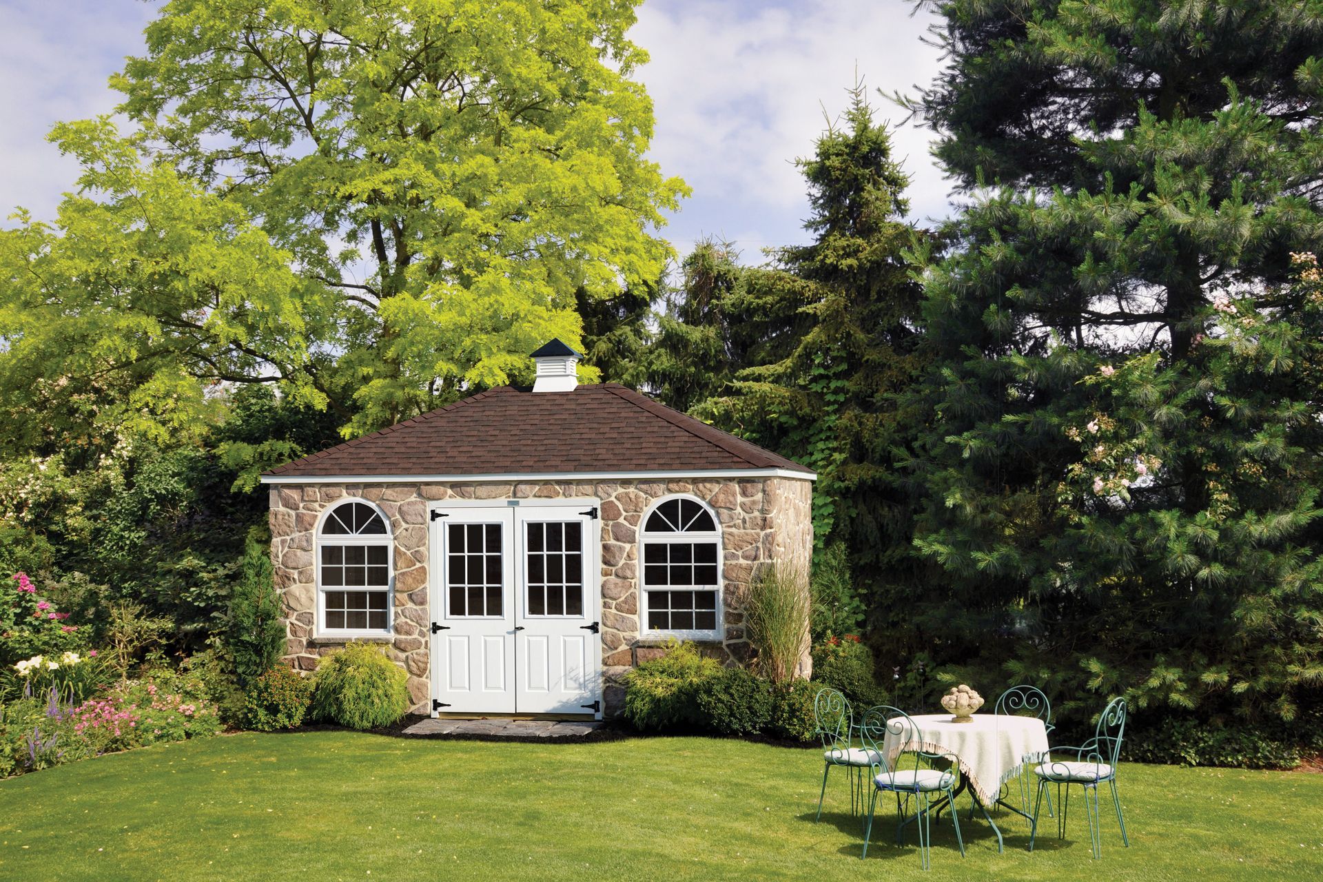 a stone house with a table and chairs in front of it